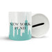 White ceramic savings jar labeled ‘New York Fund’ with a mint skyline design