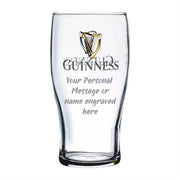 Clear Guinness beer glass with engraved text area on a white background