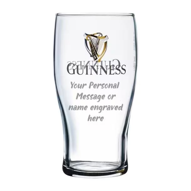 Clear Guinness beer glass with engraved text area on a white background