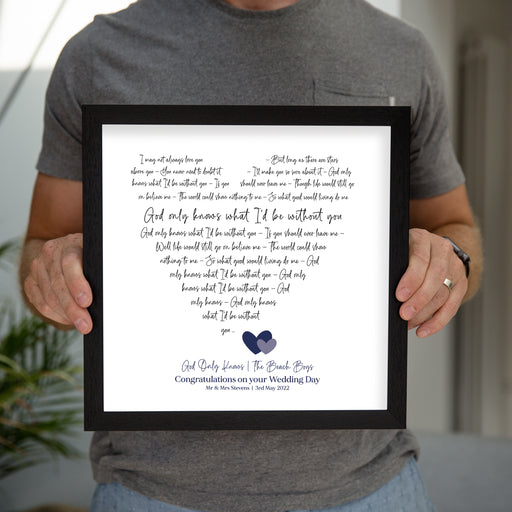 Personalised framed song lyrics print in heart of words design, held in hands