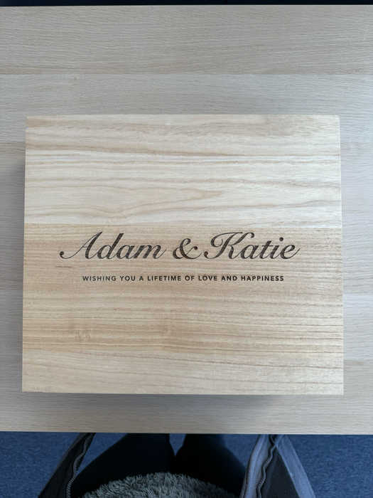 Top view of a personalised wooden wine box engraved with “Adam & Katie — Wishing you a lifetime of love and happiness.”