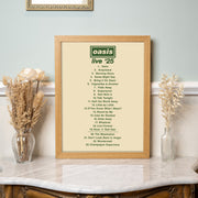 Framed Oasis 'Live '25' album tracklist on a decorative shelf with flowers.
