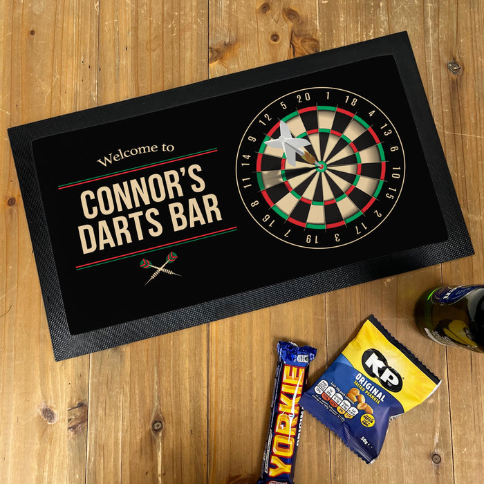 “Personalised darts bar runner featuring dartboard graphic and the text ‘Welcome to Connor’s Darts Bar’ displayed on a wooden table.”