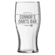 Personalised pint glass engraved with “Welcome to Connor’s Darts Bar”, shown on a white background.