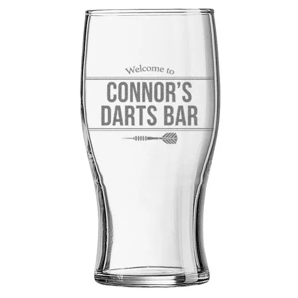 Personalised pint glass engraved with “Welcome to Connor’s Darts Bar”, shown on a white background.