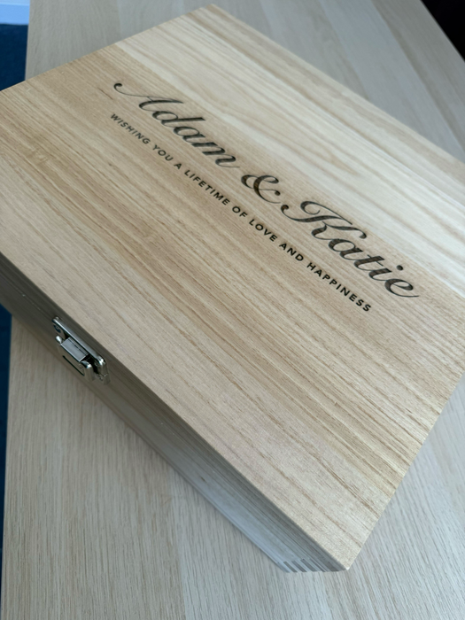 Personalised wooden wine box engraved with names and romantic message, shown at an angle to highlight the engraved text and clasp.
