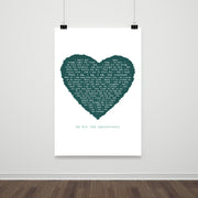 A large lyric print hanging on a white wall, featuring a deep teal heart composed of the words from “The Luckiest.” Below the heart, the message reads “On Our 2nd Anniversary.” The clean, uncluttered layout and hanging clips give it a modern and minimalist appearance.