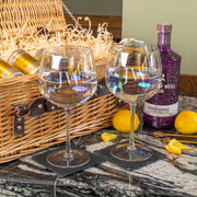 Two personalised gin glasses engraved with “JW,” paired with a wicker hamper filled with Whitley Neill gin, Fever-Tree tonic cans, and lemons.