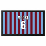 A rectangular mat with a black border and vertical blue and maroon stripes, featuring the text 'MOORE 6' in white with black outlines in the center.
