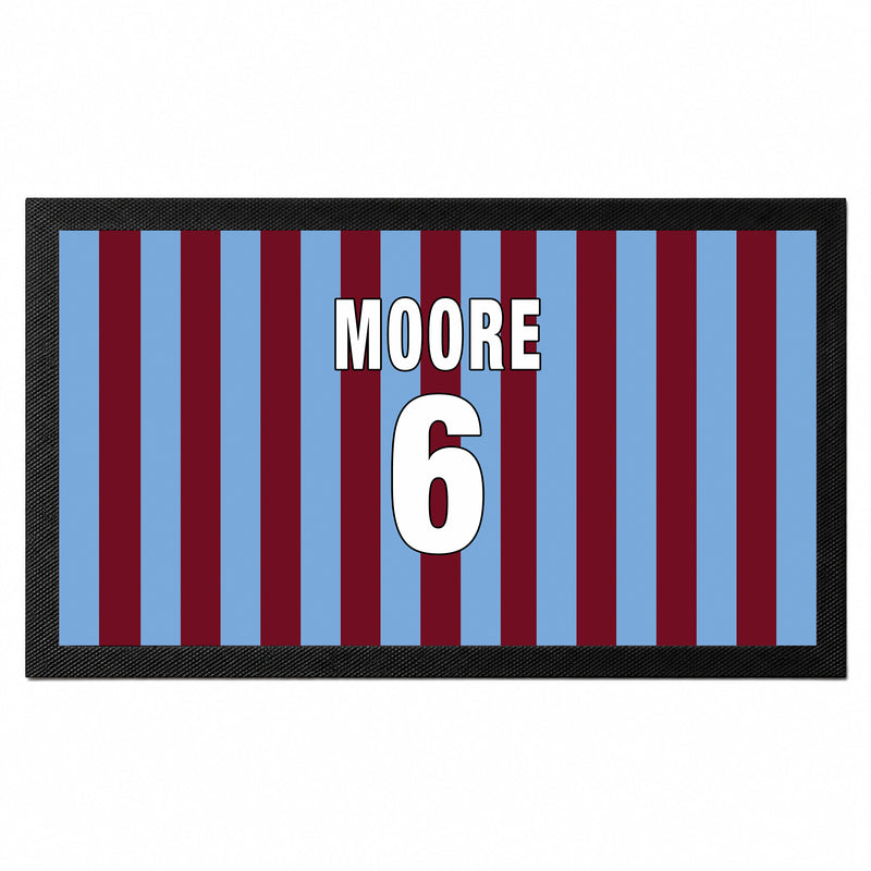 A rectangular mat with a black border and vertical blue and maroon stripes, featuring the text 'MOORE 6' in white with black outlines in the center.