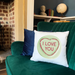 Green sofa with a 'I LOVE YOU' pillow in a cozy room.