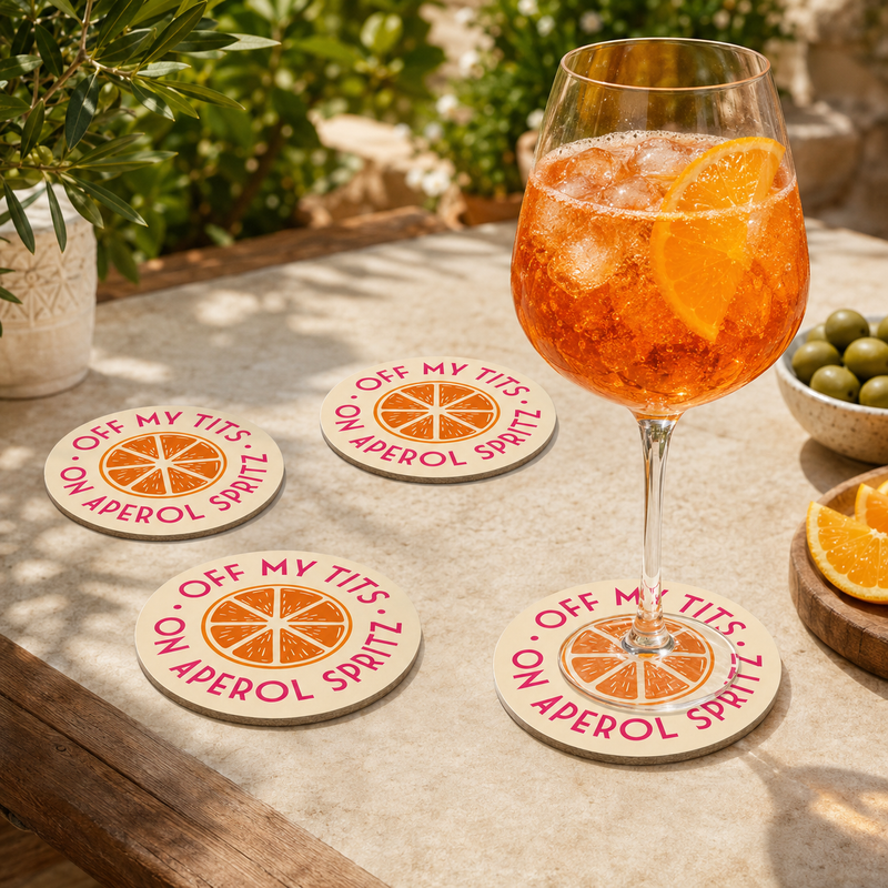 Four round Aperol Spritz coasters styled with an orange cocktail outdoors