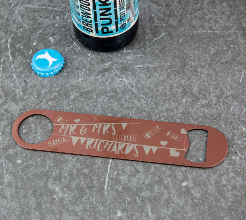 engraved bronze bar blade bottle opener with “Mr & Mrs Richards” wedding message, shown beside a BrewDog Punk IPA bottle and blue bottle cap.