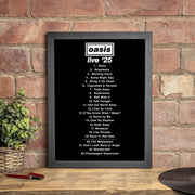 Framed list of songs from Oasis album 'Live '25' on a brick wall background