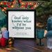 A framed print sits on a wooden outdoor table surrounded by colourful candles and glassware. The print reads in bold letters: “God only knows what I’d be without you,” with smaller text beneath saying “You’re my rock Sally. Love you forever & always, Matt xxx.” The background features blurred string lights and a cozy evening ambiance.