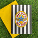 Black-and-white striped greeting card with “Best Dad in The Toon” badge design, shown with a yellow envelope on green grass background.